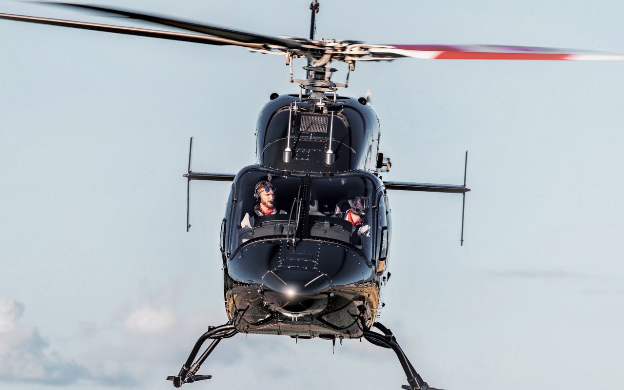 Schwarzer Bell 429 der Airport Helicopter AHB AG frontal im Flug